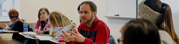 Teacher lecturing sitting close to the students