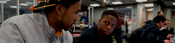 Two students in a classroom talking to each other