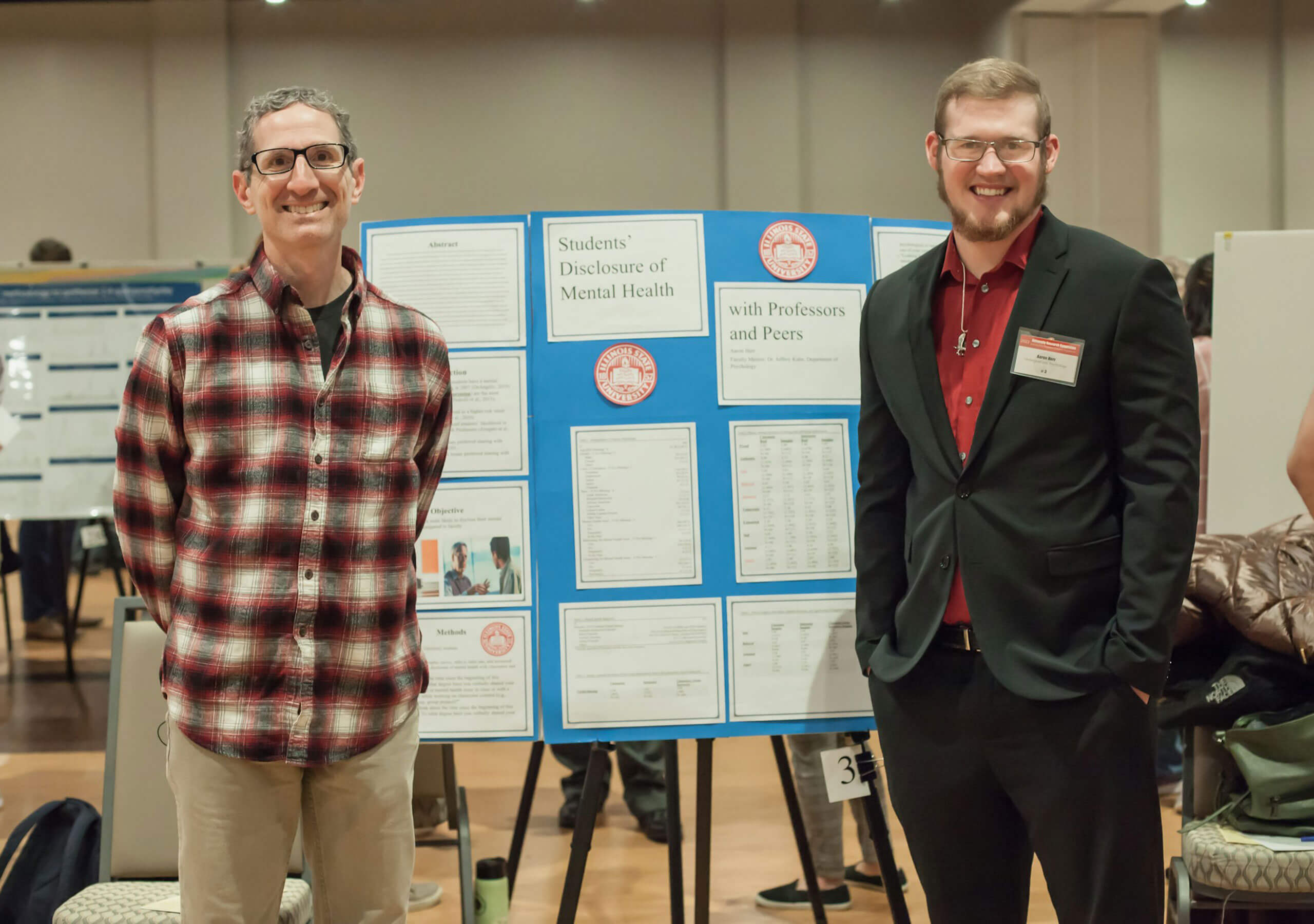 A student and teacher displaying their research poster.