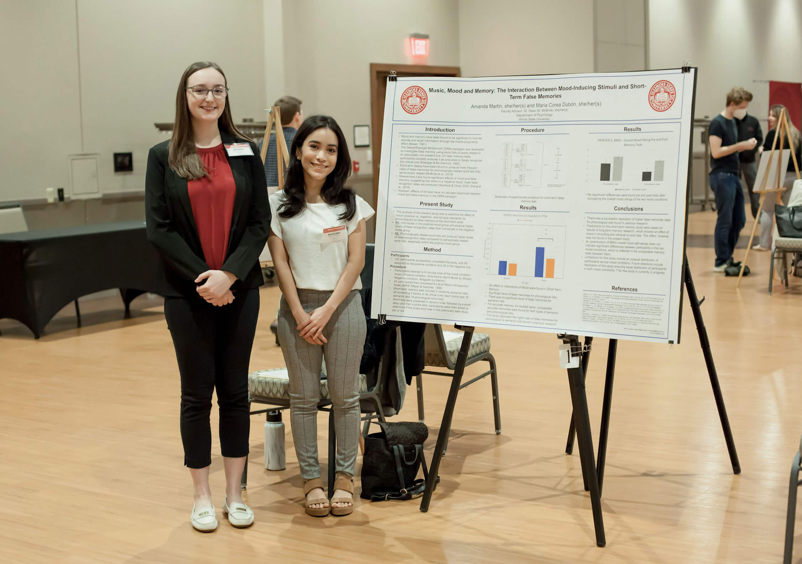 Two students displaying their research poster.